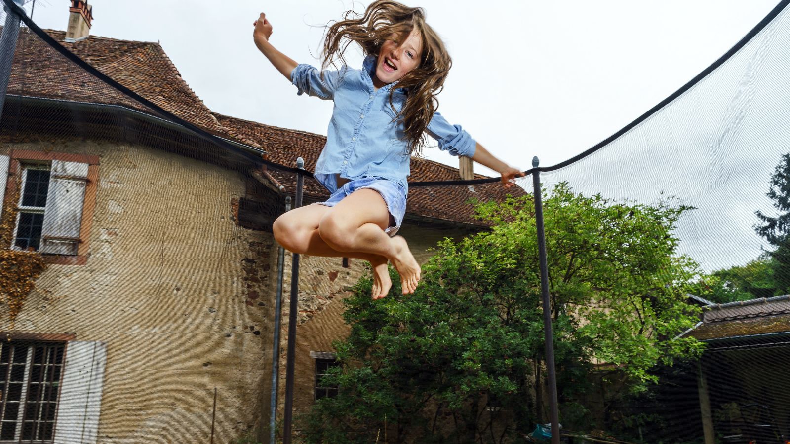 One kid jumping on a trampoline.