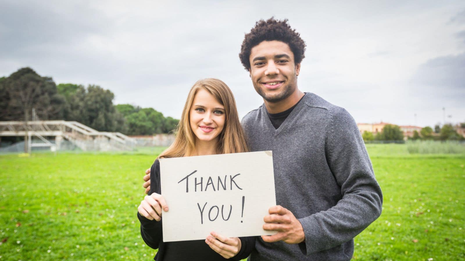 Couple Holding Thank You Sign